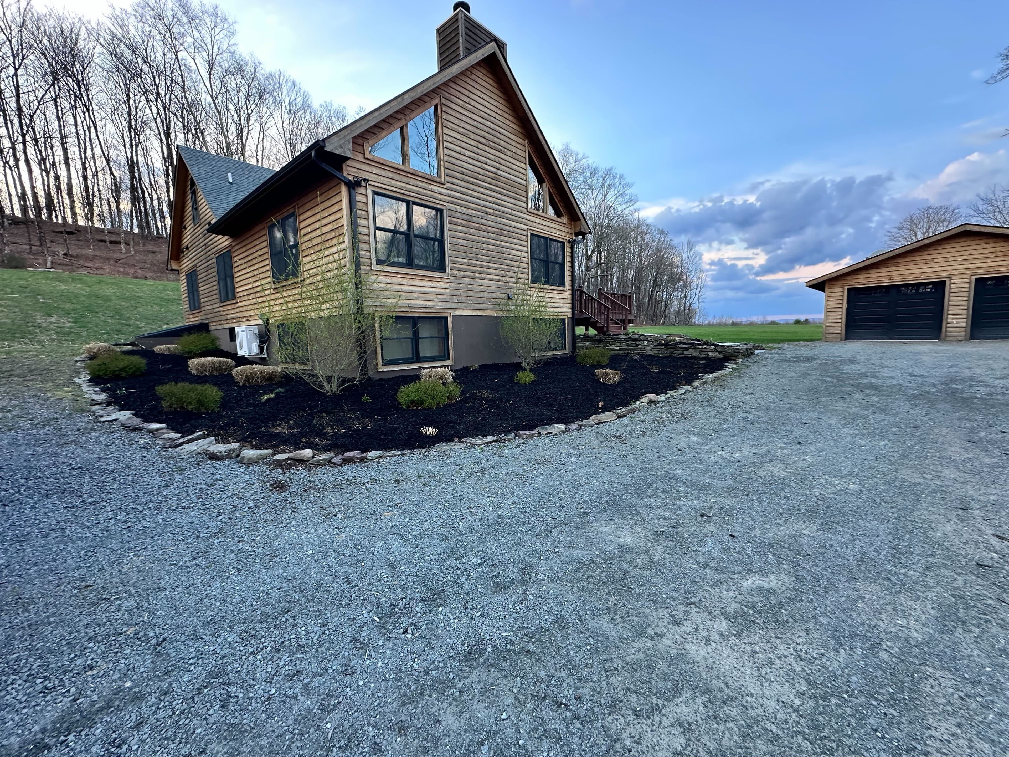 Fresh mulch bed with stone edging around a home foundation